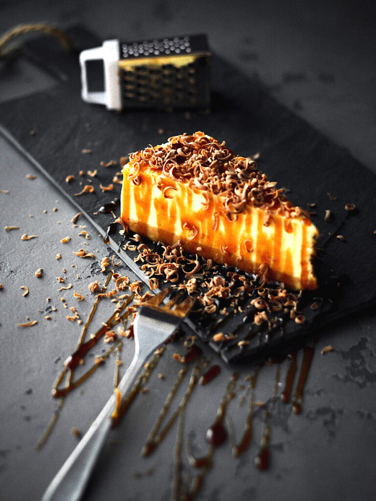 A Slice of Caramel Cake on a Black Plate, Accompanied by a Fork