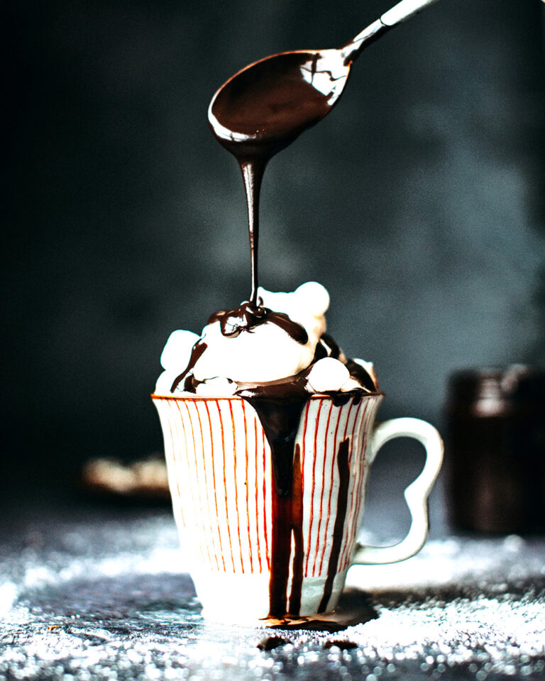 Chocolate Pouring Over Vanilla Ice Cream in a Ceramic Cup