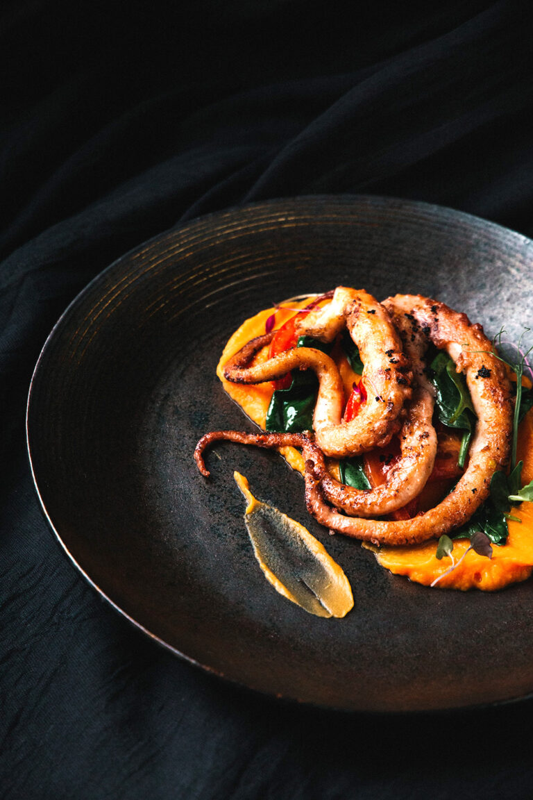 Sizzling Delight: Crispy Fried Sausage on a Black Plate