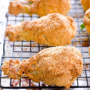 Healthy fried chicken drumsticks on a wire rack.